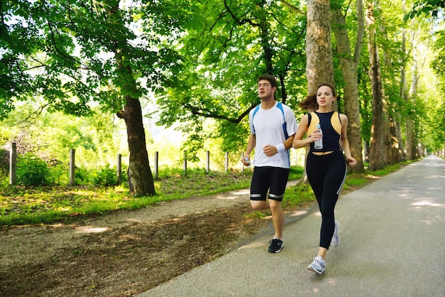 Giovani coppie che fanno jogging nel parco al mattino. Salute e fitness.