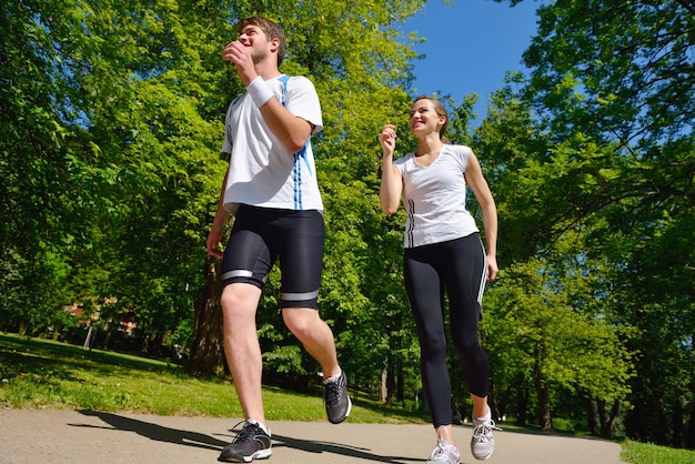 Giovani coppie che fanno jogging nel parco al mattino. Salute e fitness.