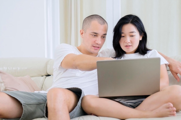 Giovani coppie che godono del tempo libero con il computer portatile