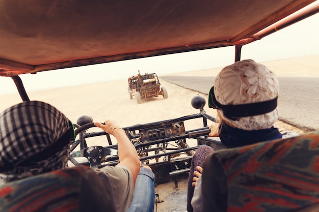 Giovani coppie che guidano automobile con errori in deserto