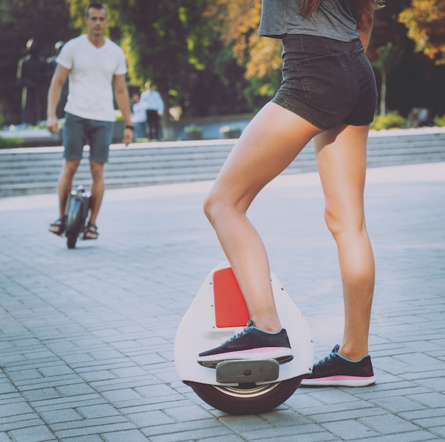 Giovani coppie che guidano sul monowheel nel parco