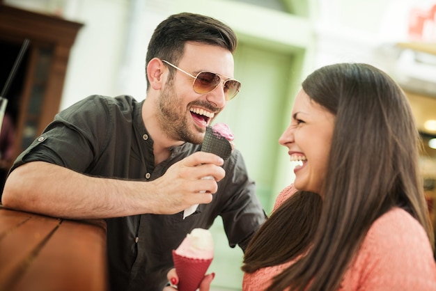 Giovani coppie che mangiano il gelato in città