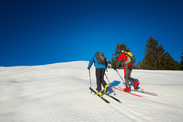 Giovani coppie che praticano sci sulla montagna