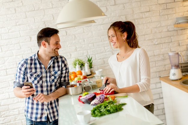 Giovani coppie che preparano pasto sano in cucina