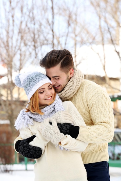 Giovani coppie che si abbracciano all'aperto in inverno