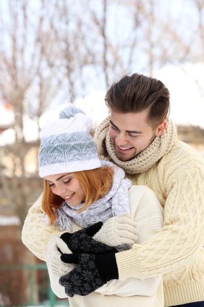 Giovani coppie che si abbracciano all'aperto in inverno