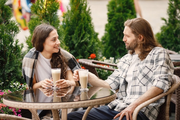 Giovani coppie che si siedono in un caffè all'aperto godendosi un caffè e una conversazione