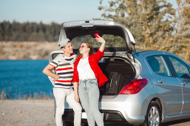 Giovani coppie che viaggiano in macchina. Donna e uomo che hanno un viaggio in automobile. Felice giovani all'aperto.