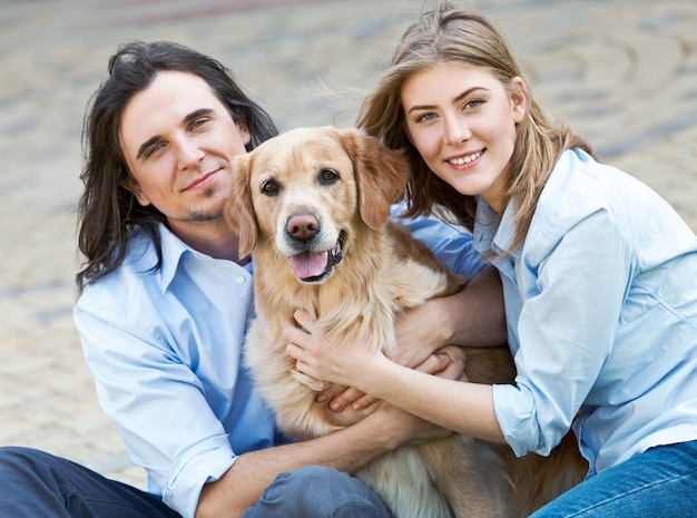 Giovani coppie con il cane che si rilassano sul litorale