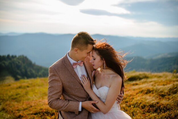 Giovani coppie di amore che celebrano un matrimonio in montagna