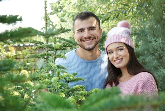 Giovani coppie felici al mercatino dell'albero di Natale