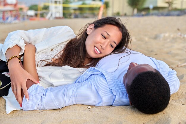 Giovani coppie felici che si trovano sulla vista superiore della sabbia