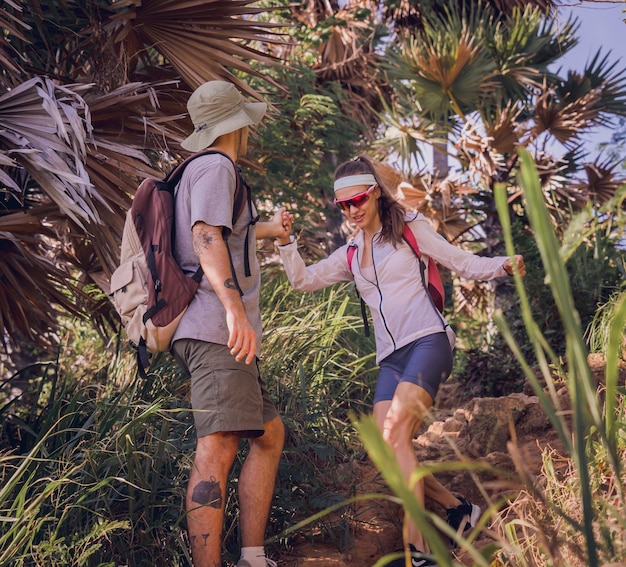 Giovani coppie felici che viaggiano nella foresta della giungla vicino all'oceano
