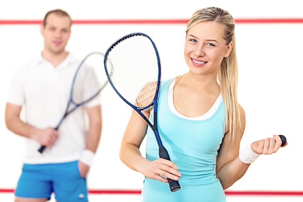 Giovani coppie felici con le racchette da tennis