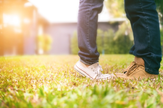 giovani coppie felici nell&#39;amore che cammina nel parco che tengono le mani e baciare nel tramonto