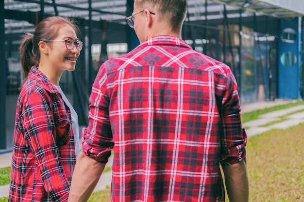 giovani coppie felici nell&#39;amore che cammina nel parco che tengono le mani