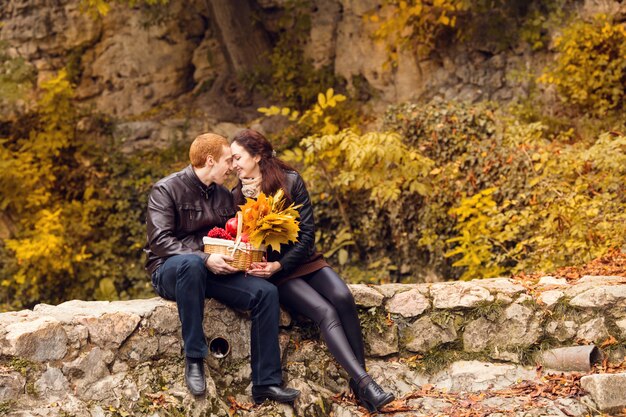 Giovani coppie felici nella riunione di amore sulla foglia di autunno