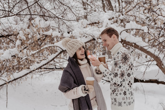 Giovani coppie felici nella sosta di inverno che ha divertimento. Famiglia all&#39;aperto. amore