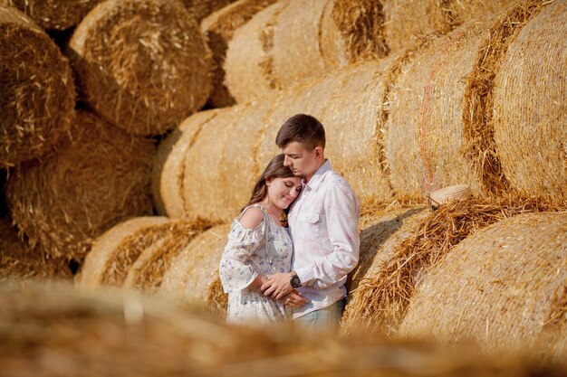 Giovani coppie felici su paglia, persone romantiche, bello paesaggio, stagione estiva