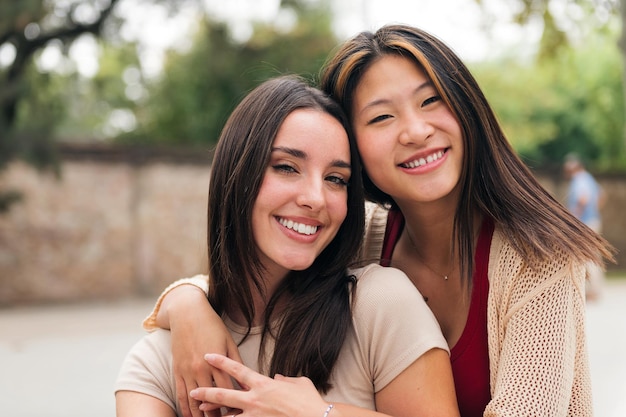 Giovani coppie femminili che sorridono e che esaminano macchina fotografica