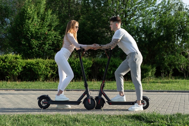 Giovani coppie nel parco sugli scooter elettrici