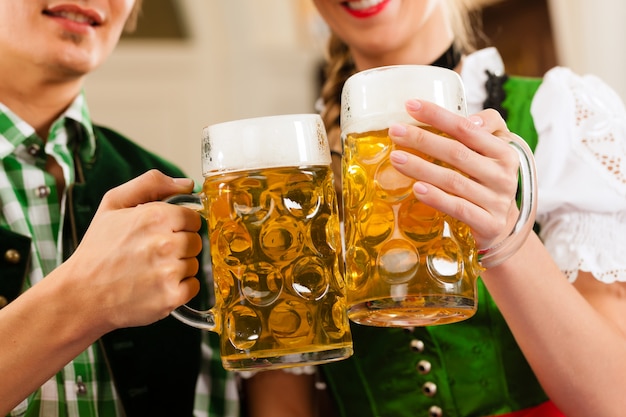 Giovani coppie nel tradizionale bavarese Tracht in ristorante o pub