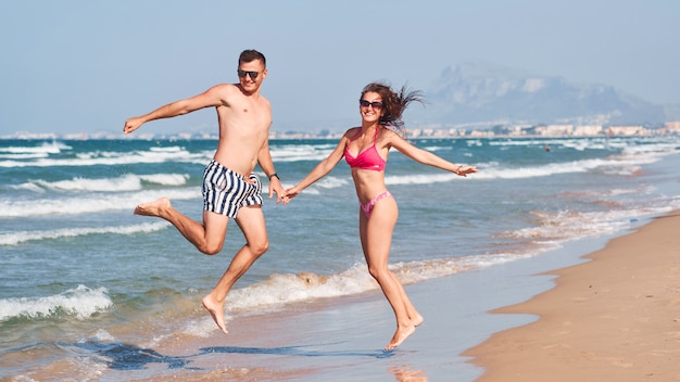 Giovani coppie nell'amore che cammina sulla spiaggia.