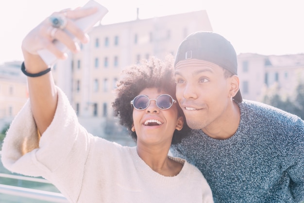 Giovani coppie nere che prendono selfie