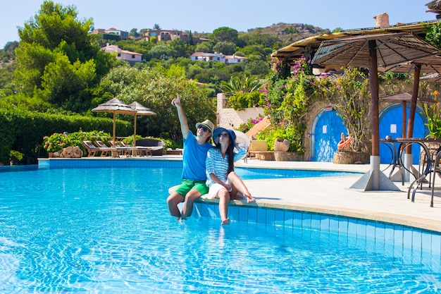 Giovani coppie romantiche adorabili che si rilassano dalla piscina