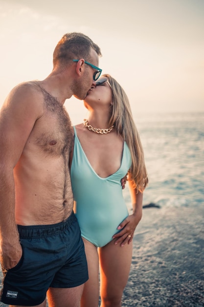 Giovani coppie romantiche innamorate che camminano insieme al tramonto lungo la spiaggia del Mediterraneo Vacanze estive in un paese caldo Coppia sposata felice in vacanza in Turchia Messa a fuoco selettiva