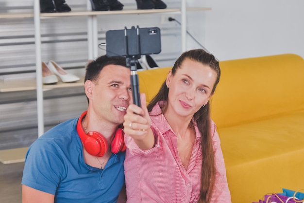 Giovani coppie sorridenti felici che si rilassano su un divano a casa facendo una famiglia di videochiamate