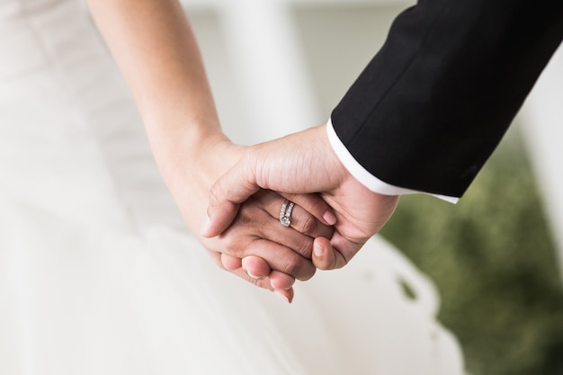 Giovani coppie sposate che si tengono per mano, giorno delle nozze di cerimonia