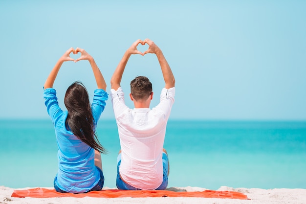 Giovani coppie sulla spiaggia bianca durante le vacanze estive.