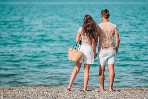 Giovani coppie sulla spiaggia bianca durante le vacanze estive.