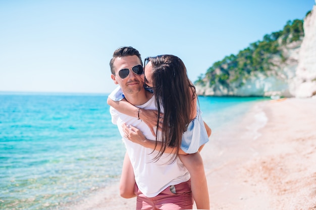 Giovani coppie sulla spiaggia bianca durante le vacanze estive.