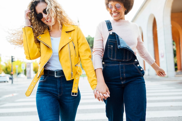 Giovani donne alla moda che hanno riunione amichevole che cammina nella via. Concetto LGTB