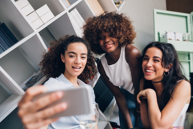 giovani donne che assumono selfie con smartphone e divertirsi in posizione moderna