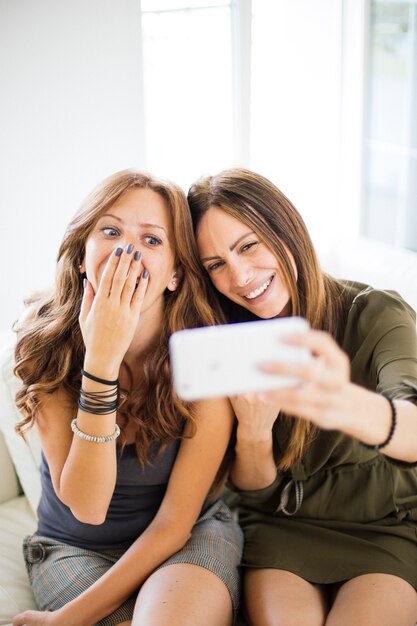 Giovani donne che assumono selfie nella stanza