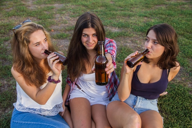 Giovani donne che bevono birra nel parco