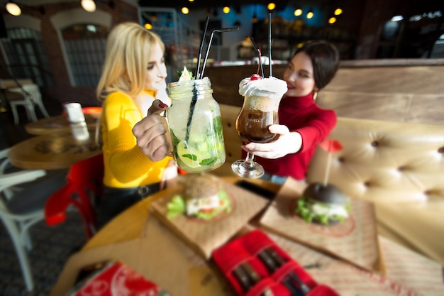 Giovani donne che brindano a bicchieri da cocktail
