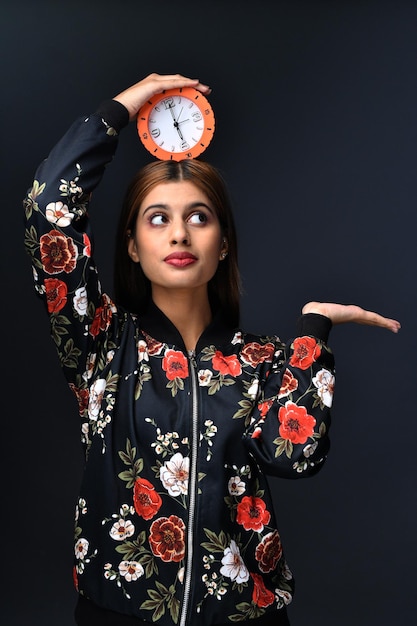 giovani donne che indossano abiti casual e tengono l'orologio sopra la sua testa modello pakistano indiano