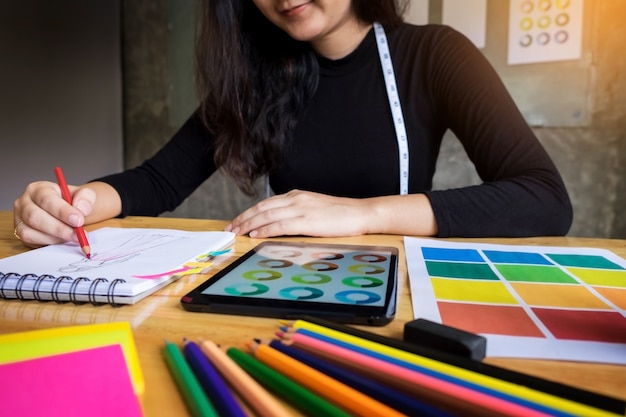 giovani donne che lavorano come disegni di moda disegno disegni per vestiti in atelier carta sul posto di lavoro studio.