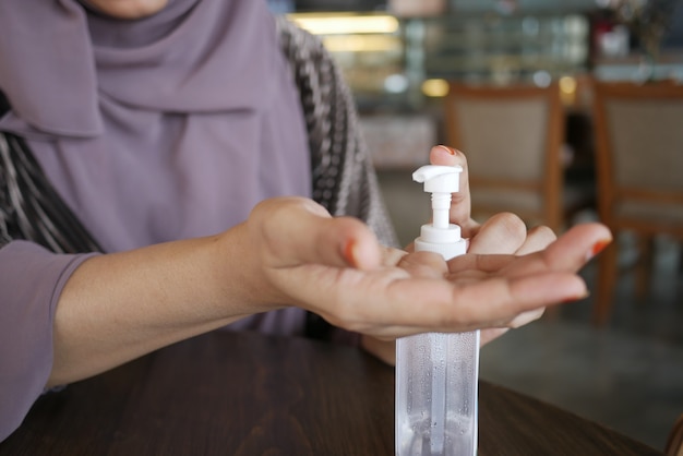 giovani donne che usano disinfettante per le mani al bar