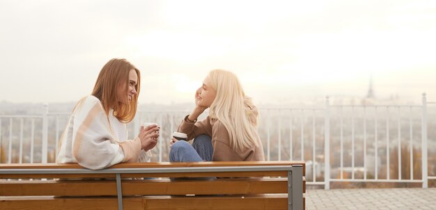 Giovani donne con caffè parlando sul banco