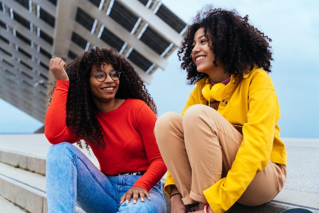 Giovani donne felici divertendosi all'aperto ridendo e condividendo il buon umore