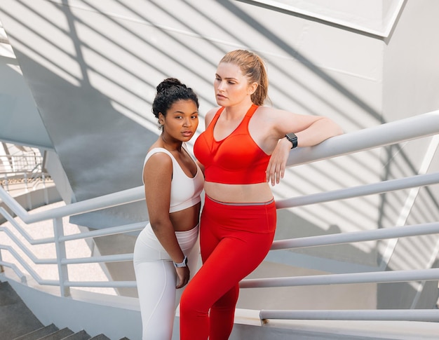 Giovani donne in abbigliamento sportivo con corpi più grandi in piedi insieme