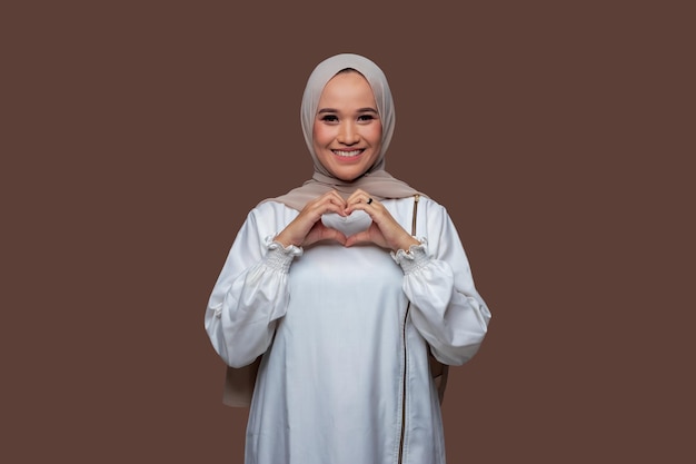 Giovani donne indonesiane che indossano l'hijab che mostrano gesti delle mani a forma di cuore