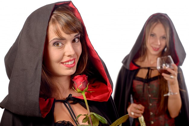 giovani donne mascherate da halloween con un bicchiere di sangue e una rosa