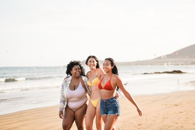 Giovani donne multirazziali che si divertono insieme camminando sulla spiaggia - ragazze latine con diversi colori della pelle e corpi - Concetto di amicizia e felicità