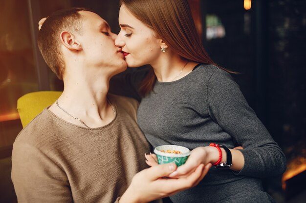 Giovani e coppie amorose che si siedono in un caffè